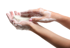 Hände werden mit einem Seifenstück eingeseift.
