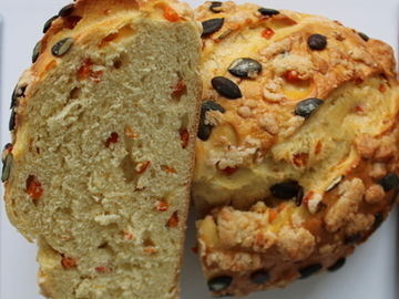 Aufgeschnittenes Kürbisbrot mit Kürbiskernen auf einer Platte.
