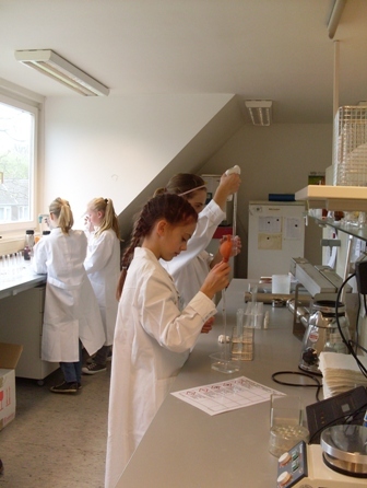 Mädchen in weißen Kitteln experimentieren mit verschiedenen Pipettierhilfen