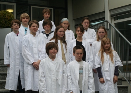 Gruppenfoto von 13 Kindern in weißen Kitteln