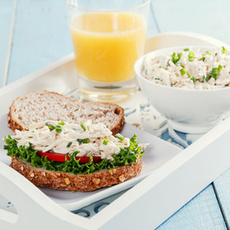 Tablett mit einer Scheibe Brot darauf Feinkostsalat