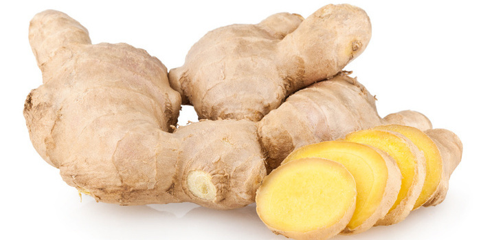 Es ist eine Ingwerwurzel mit aufgeschnittenen Ingwerscheiben zu sehen.