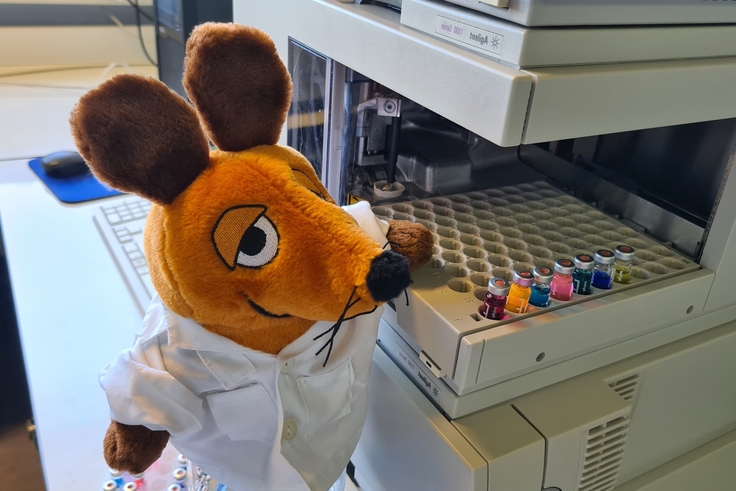 Die Maus (von der Sendung mit der Maus) mit Farbstoffproben an einem Laborgerät