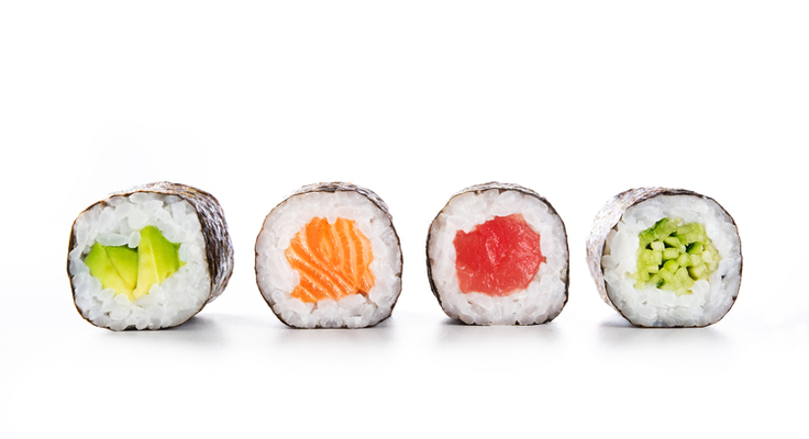 Sushi-Rollen mit Fisch, Reis und Gemüse gefüllt
