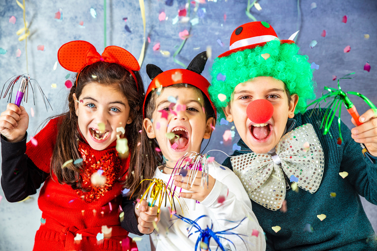 Kinder in bunten Faschingskostümen verkleidet feiern Karneval