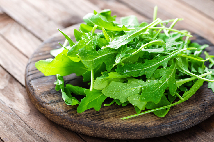 Rucola liegt auf einem Holzbrett.