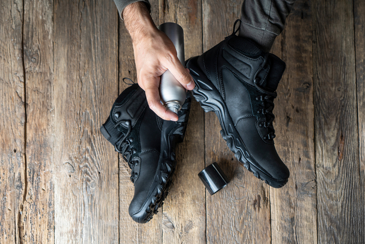 Trekkingschuhe werden mit Imprägnierspray eingesprüht.