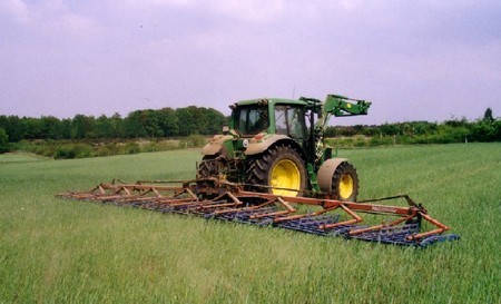 Landwirt beim striegeln seines Getreides