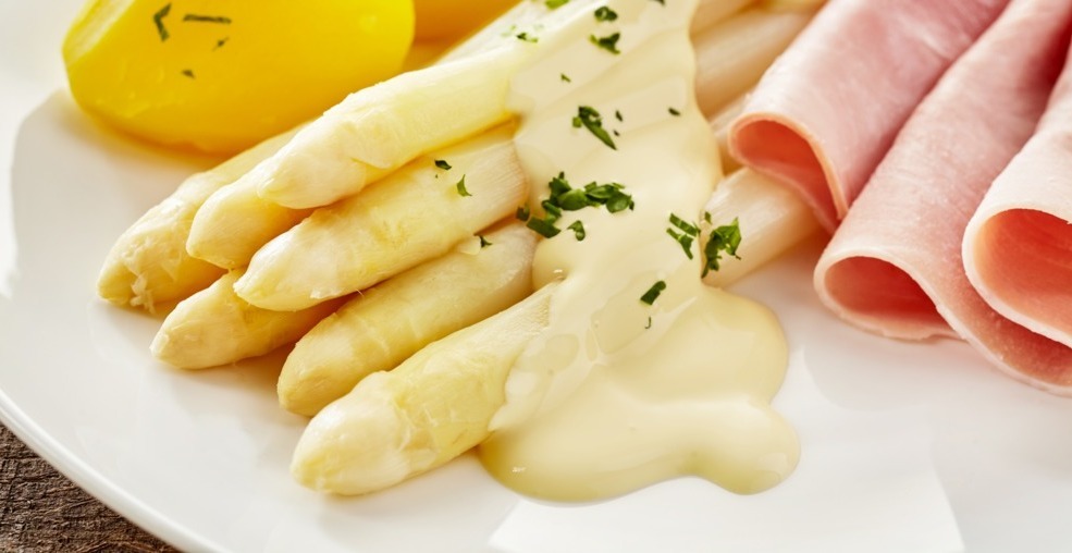 Weiße Spargelstangen mit Sauce Hollandaise und Schinken