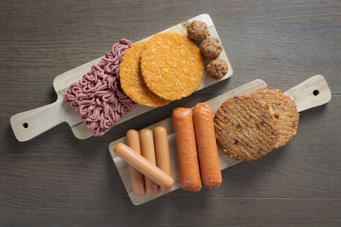 Vegetarian meat substitute products are arranged on two cutting boards.
