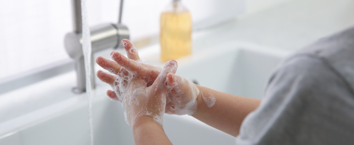 Kind wäscht sich am Waschbecken mit Handseife die Hände
