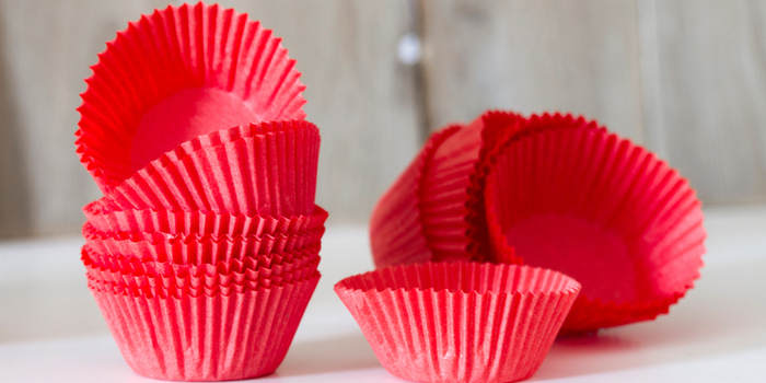 Rote Muffinförmchen aus Papier liegen aufgestapelt nebeneinander.