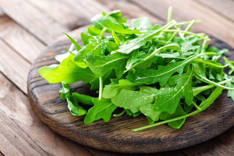 Rucola liegt auf einem Holzbrett.