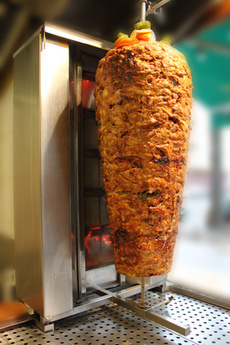 Döner Kebab-Drehspieß vor dem Grill