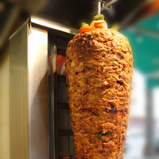 Döner Kebab-Drehspieß vor dem Grill